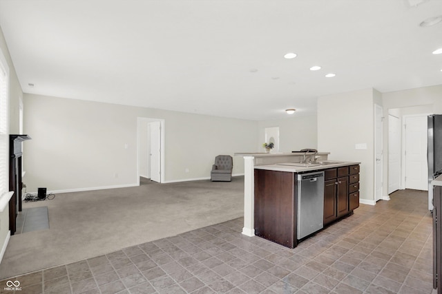 kitchen with baseboards, stainless steel dishwasher, dark brown cabinetry, and light colored carpet