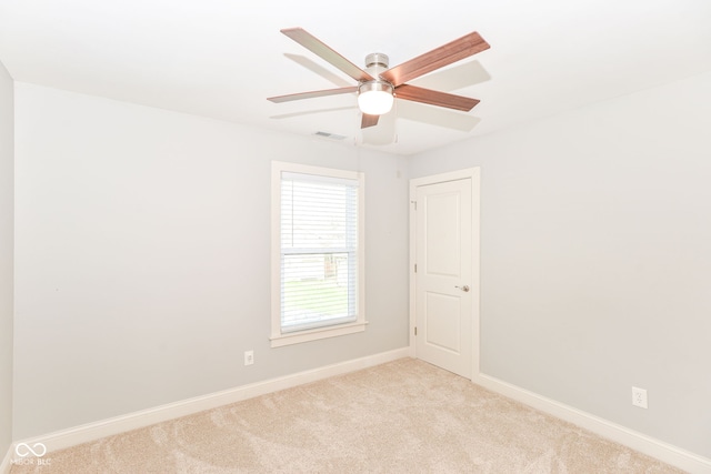 empty room featuring baseboards, light carpet, visible vents, and ceiling fan