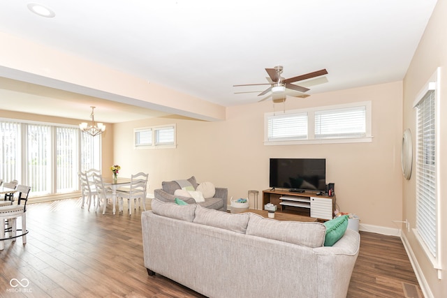living room with ceiling fan with notable chandelier, baseboards, and dark wood-style floors