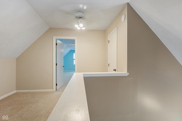 bonus room with a ceiling fan, baseboards, light colored carpet, and lofted ceiling