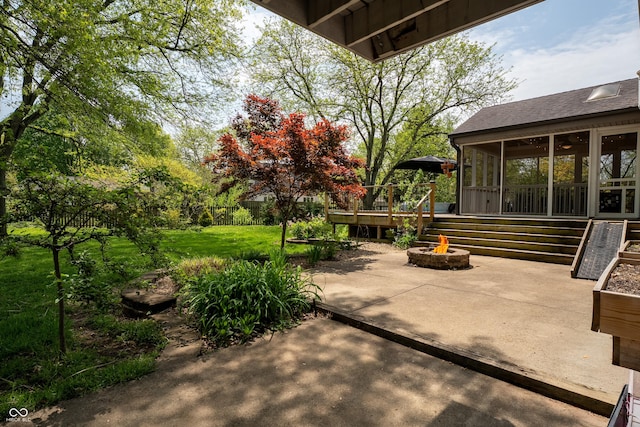 view of patio / terrace featuring a fire pit, a sunroom, and a wooden deck