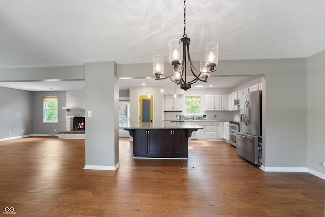 kitchen featuring appliances with stainless steel finishes, a notable chandelier, white cabinetry, open floor plan, and dark wood-style floors