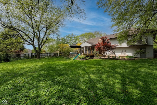 view of yard featuring a sunroom and a fenced backyard