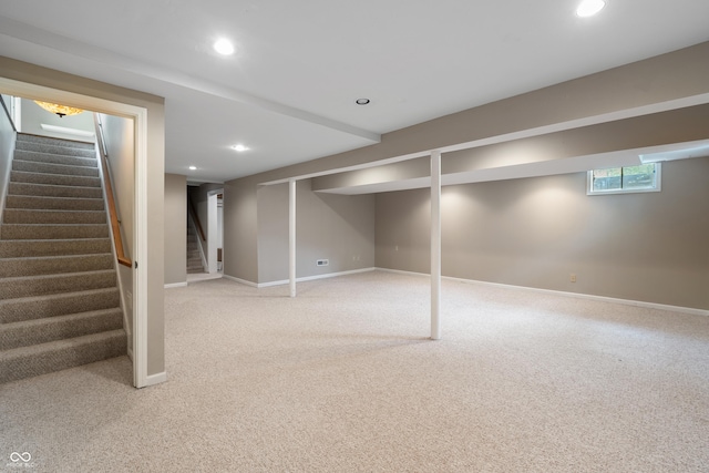 below grade area with stairway, baseboards, recessed lighting, and light colored carpet