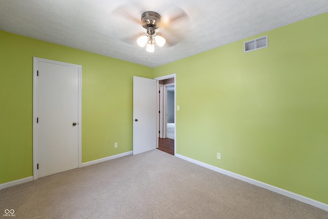 unfurnished bedroom featuring visible vents, carpet floors, baseboards, a textured ceiling, and a ceiling fan