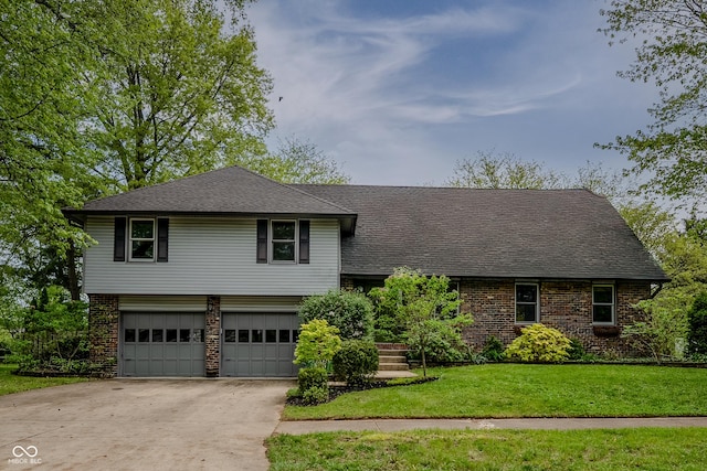 tri-level home with a garage, a front lawn, brick siding, a shingled roof, and driveway