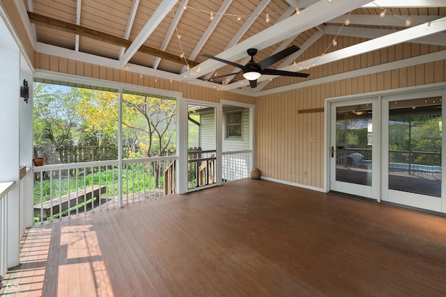 unfurnished sunroom featuring ceiling fan and beamed ceiling