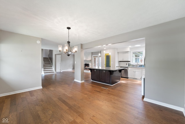 kitchen featuring baseboards, white cabinets, dark wood-type flooring, and dishwasher