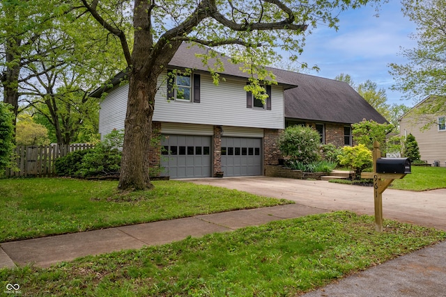 tri-level home featuring fence, a front yard, brick siding, concrete driveway, and an attached garage