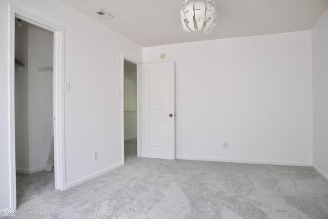 5236 Skipping Stone Dr, Indianapolis, IN 46237 - unfurnished bedroom with a closet, a walk in closet, visible vents, baseboards, and carpet floors