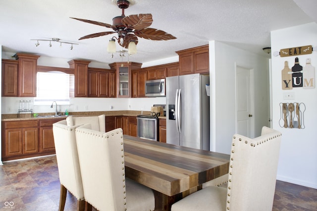 5236 Skipping Stone Dr, Indianapolis, IN 46237 - kitchen with brown cabinets, glass insert cabinets, a sink, appliances with stainless steel finishes, and ceiling fan