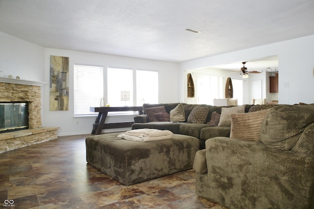 5236 Skipping Stone Dr, Indianapolis, IN 46237 - living area featuring a fireplace, stone finish floor, visible vents, and a ceiling fan
