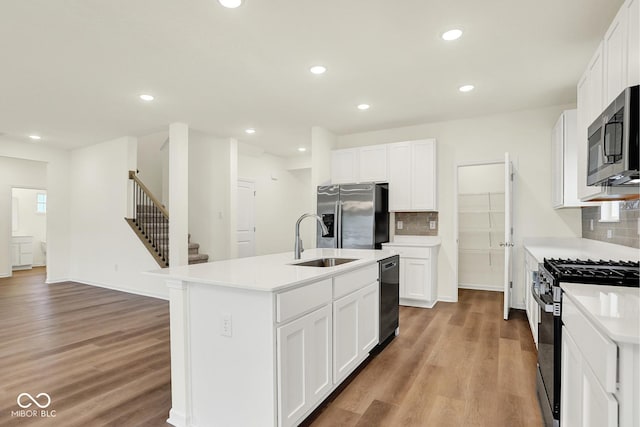 2712 Glade Ave, Plainfield, IN 46168 - kitchen featuring stainless steel appliances, a sink, light wood finished floors, decorative backsplash, and recessed lighting