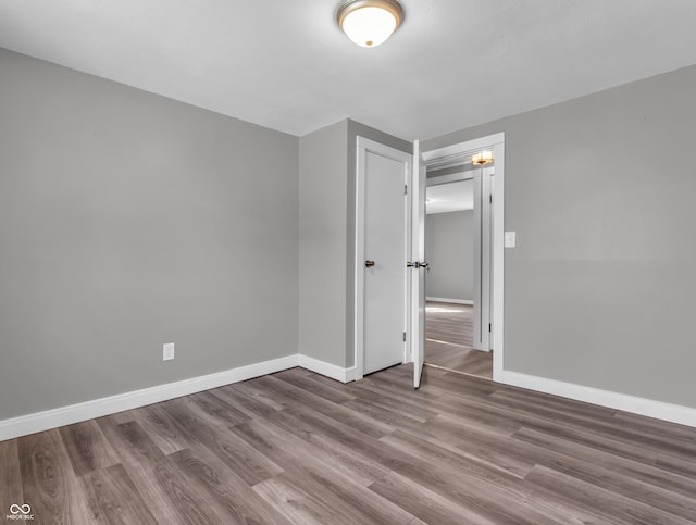 unfurnished bedroom with baseboards and wood finished floors