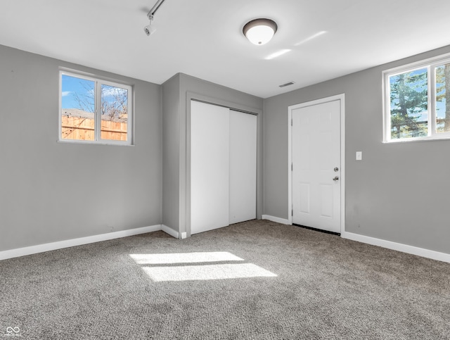 unfurnished bedroom featuring baseboards, visible vents, a closet, and carpet flooring