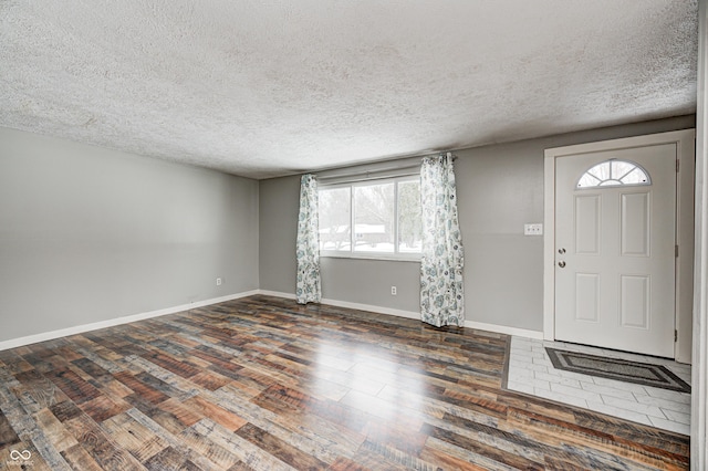 entrance foyer with wood finished floors, a textured ceiling, and baseboards