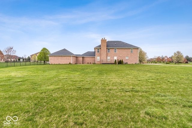 6519 Rothchild Blvd, Indianapolis, IN 46278 - rear view of house with a yard, a chimney, and fence