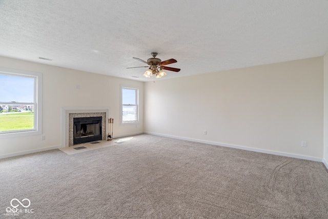 6519 Rothchild Blvd, Indianapolis, IN 46278 - unfurnished living room featuring visible vents, a ceiling fan, baseboards, a tiled fireplace, and carpet flooring