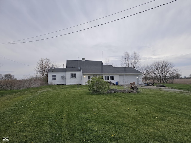 back of house with an attached garage and a yard