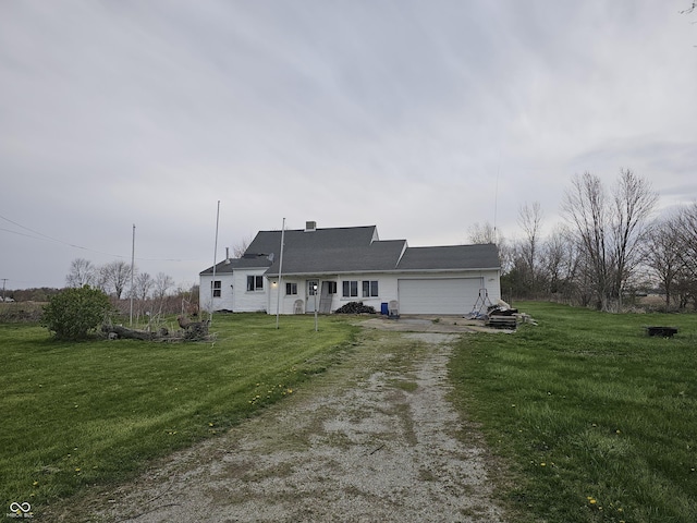 view of front of house featuring an attached garage, dirt driveway, and a front yard