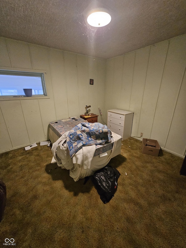 bedroom featuring dark carpet and a textured ceiling