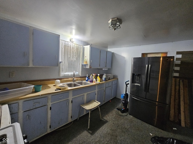 kitchen featuring light countertops, dark colored carpet, gray cabinets, a sink, and black fridge