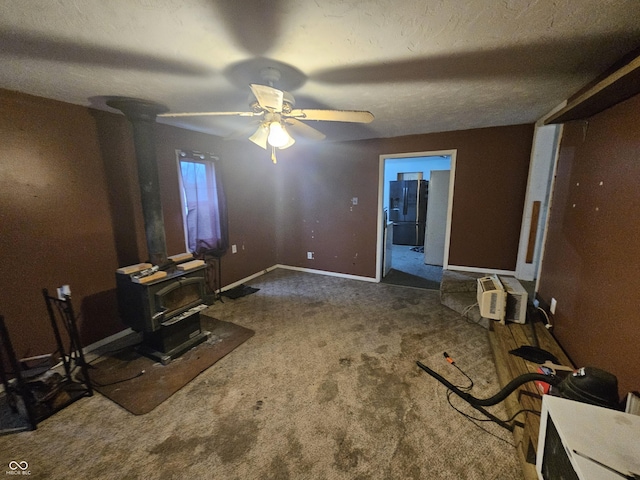interior space with baseboards, a wall mounted air conditioner, refrigerator with ice dispenser, carpet floors, and a wood stove