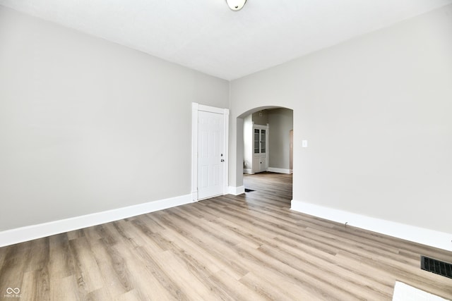 106 S Wayburn St, Indianapolis, IN 46229 - empty room featuring arched walkways, wood finished floors, visible vents, and baseboards