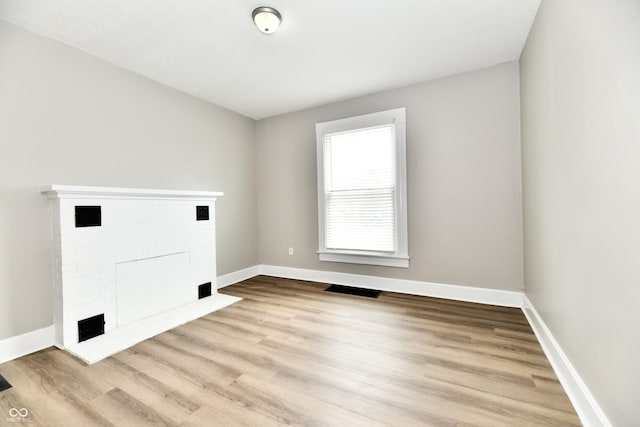 106 S Wayburn St, Indianapolis, IN 46229 - laundry room featuring wood finished floors, a brick fireplace, baseboards, and visible vents