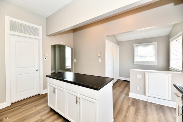 106 S Wayburn St, Indianapolis, IN 46229 - kitchen featuring arched walkways, dark countertops, white cabinetry, and light wood-style flooring