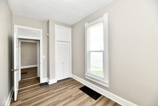 106 S Wayburn St, Indianapolis, IN 46229 - unfurnished bedroom featuring baseboards, wood finished floors, visible vents, and a closet