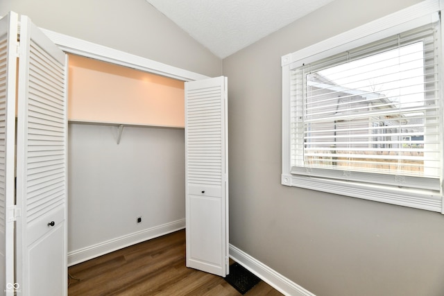 106 S Wayburn St, Indianapolis, IN 46229 - unfurnished bedroom with baseboards, vaulted ceiling, a closet, and dark wood-style floors