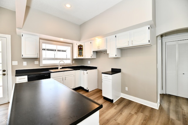 106 S Wayburn St, Indianapolis, IN 46229 - kitchen with dark countertops, a sink, light wood-type flooring, black dishwasher, and white cabinetry