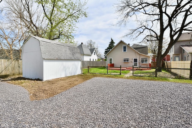 106 S Wayburn St, Indianapolis, IN 46229 - view of yard featuring a storage unit, an outbuilding, a fenced backyard, and a deck