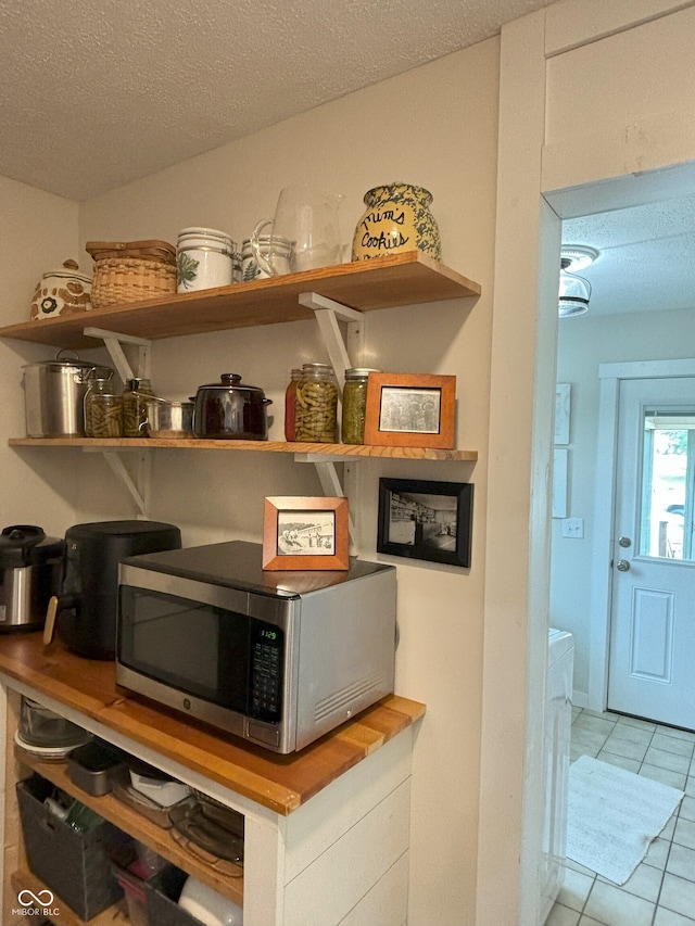 details featuring a textured ceiling and stainless steel microwave
