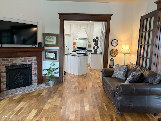living room featuring a fireplace and light wood-type flooring