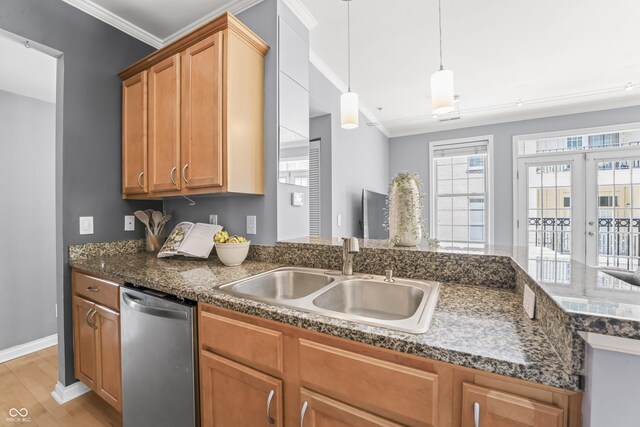kitchen featuring crown molding, dishwasher, a sink, baseboards, and light wood-style flooring