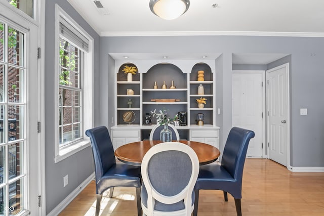 dining area featuring light wood-type flooring, baseboards, crown molding, and visible vents