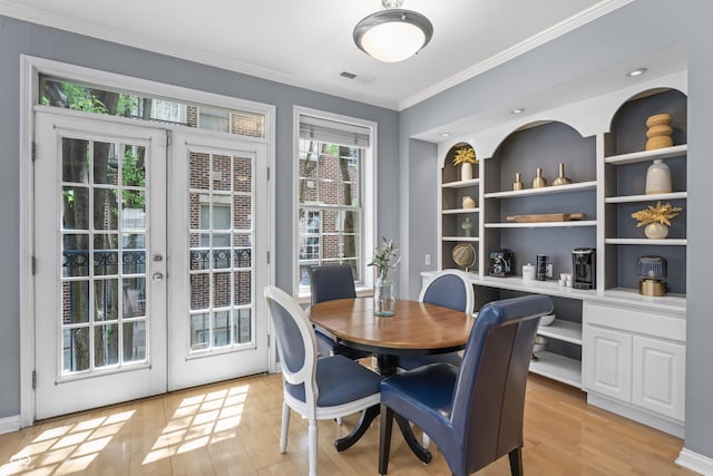dining area featuring french doors, visible vents, crown molding, light wood-type flooring, and built in desk