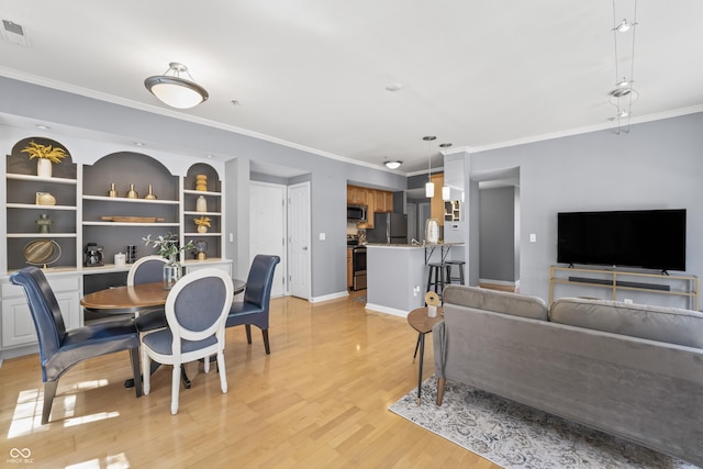 interior space featuring light wood-style floors, ornamental molding, baseboards, and visible vents
