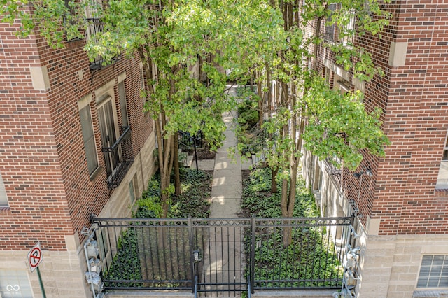 view of property exterior featuring brick siding, a gate, and fence private yard