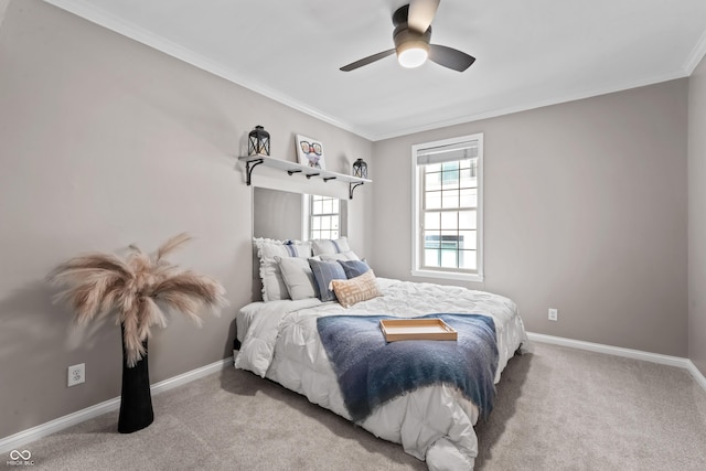 carpeted bedroom with crown molding, baseboards, and ceiling fan