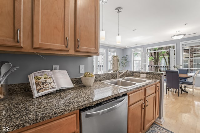 kitchen with a sink, brown cabinetry, light wood-type flooring, and dishwasher
