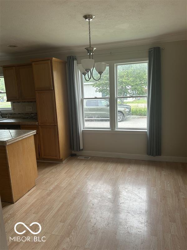 1640 Lawton Ave, Columbus, IN 47201 - unfurnished dining area with ornamental molding, a chandelier, light wood-type flooring, and a textured ceiling