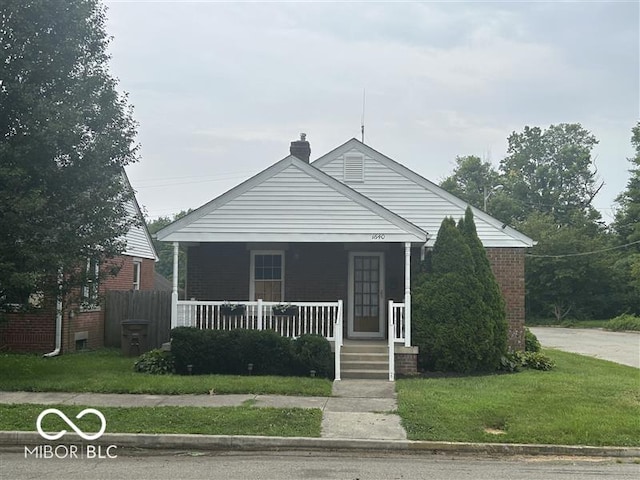 1640 Lawton Ave, Columbus, IN 47201 - bungalow-style home featuring covered porch, a front lawn, a chimney, and brick siding