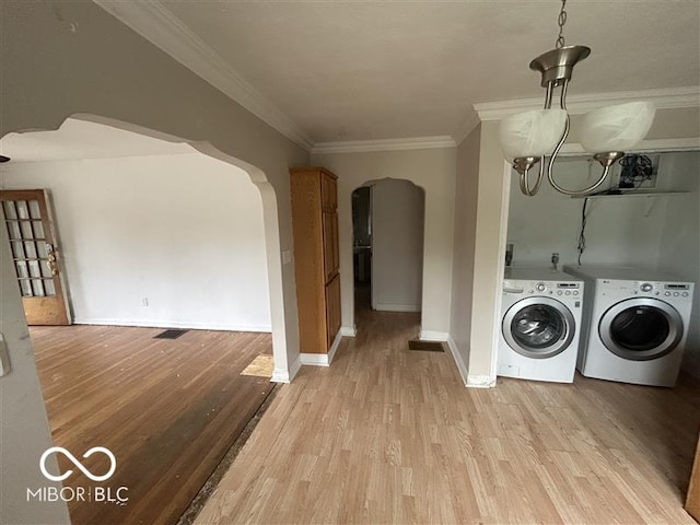 1640 Lawton Ave, Columbus, IN 47201 - washroom with arched walkways, washing machine and clothes dryer, light wood finished floors, and crown molding