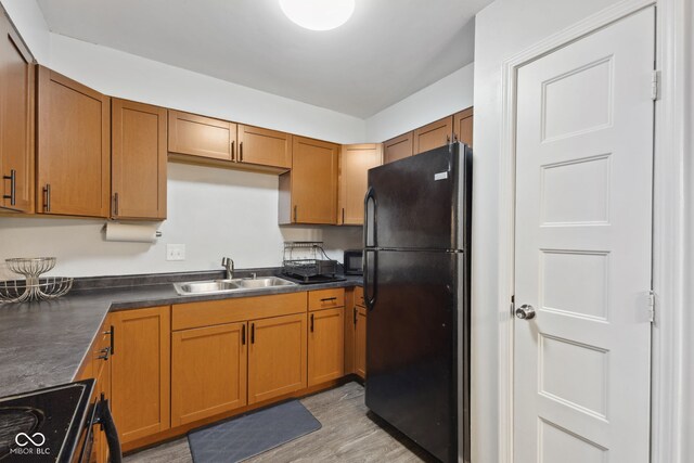 4464 Four Seasons Cir, Indianapolis, IN 46226 - kitchen with a sink, dark countertops, freestanding refrigerator, brown cabinetry, and electric stove