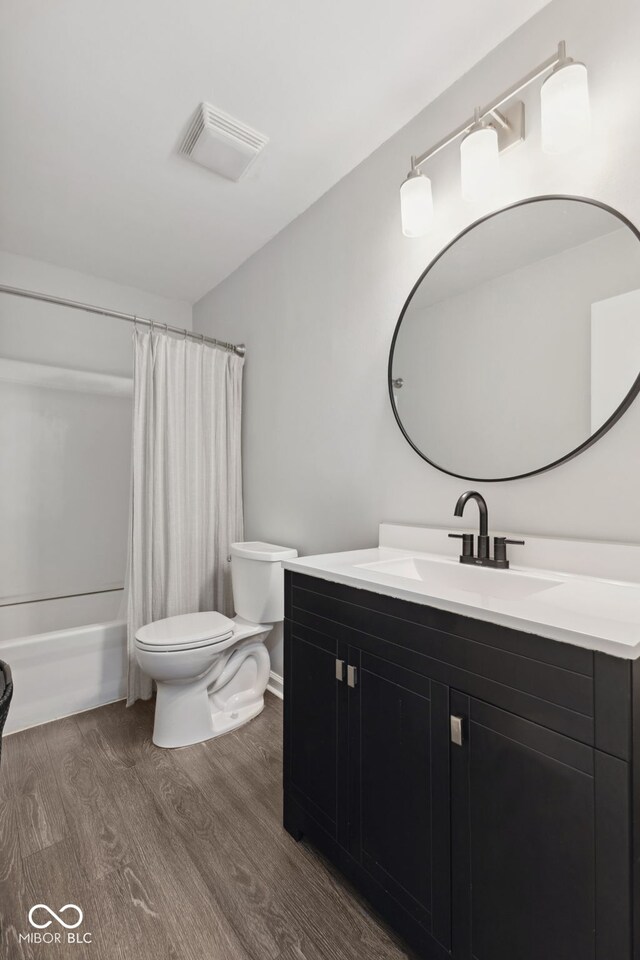 4464 Four Seasons Cir, Indianapolis, IN 46226 - bathroom featuring wood finished floors, visible vents, toilet, vanity, and shower / bath combo