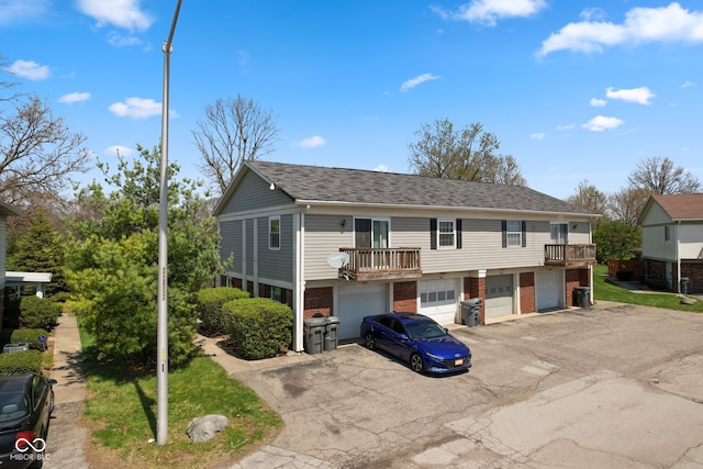 4464 Four Seasons Cir, Indianapolis, IN 46226 - view of front facade with a garage, brick siding, aphalt driveway, and roof with shingles