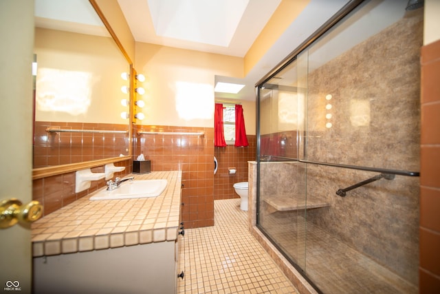 4710 E 56th St, Indianapolis, IN 46220 - bathroom with tile patterned flooring, tile walls, toilet, vanity, and a stall shower